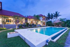 乌布Champaca Luxury Villas Ubud的房屋前的游泳池