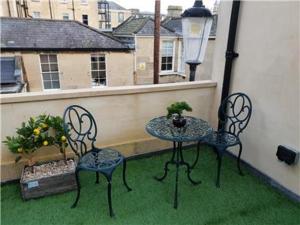 巴斯Chapel Lodge - Roof top garden!Perfect for your family的阳台的天井配有2把椅子和1张桌子