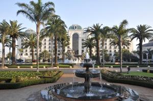 肯普顿帕克皮蒙特德奥瑞勒皇宫大酒店的棕榈树建筑前的喷泉