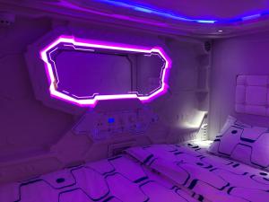 马尼拉Dormitos的客房设有电视和紫色灯床。