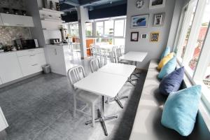 华欣华欣月亮旅舍的厨房以及带白色桌子和蓝色枕头的用餐室。