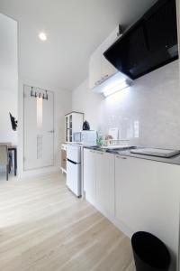 滨松Culinary Bed&Art 402的白色的厨房配有白色家电,铺有木地板