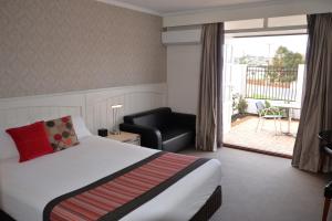 奥尔巴尼艾米蒂乡村舒适汽车旅馆的酒店客房带一张床、椅子和阳台