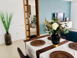 纳萨雷特Canaryislandshost l Infinity Views的一间设有两张桌子和花瓶的用餐室