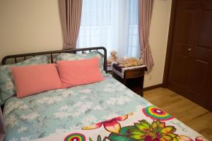 宇流麻La Fata的一间卧室配有带粉红色枕头的床。