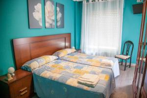 洛格罗尼奥巴赫克德尔埃布罗旅馆的一间卧室配有一张蓝色墙壁的床和一扇窗户