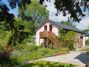 兰达弗里Seren Loft - Cynghordy, Llandovery的一座粉红色的小房子,设有门廊和甲板
