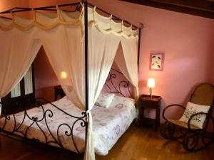 Alboreca阿尔伯瑞卡阳台酒店的一间卧室配有一张天蓬床和一把椅子