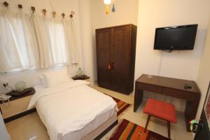纳布卢斯Khan Alwakala Hotel的一间小卧室,配有一张床和电视