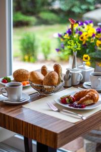 塞巴特阿尔贝克德利亚维尔旅馆的桌子上摆着一张桌子,上面放着糕点和羊角面包,还有窗户