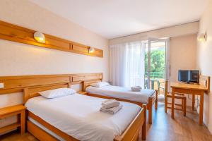 波尔尼谢Azureva Pornichet Baie de La Baule的酒店客房设有两张床和电视。