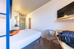 布雷斯地区布尔格布雷斯布尔格宜必思快捷酒店的小房间设有床铺和电视