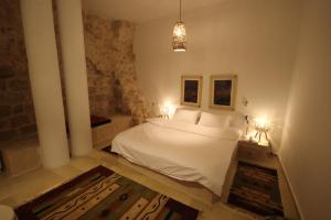 纳布卢斯Khan Alwakala Hotel的卧室配有白色的床和两盏灯。