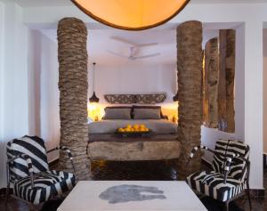 塔哈佐特Munga Guesthouse的一间卧室配有一张带两把椅子和一张桌子的床。