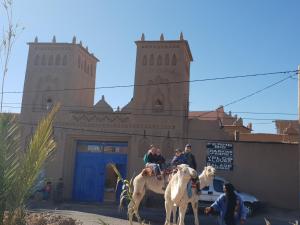 斯库拉Gite Kasbah La Palmeraie的一群人骑马在建筑前