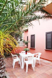 罗萨岛蓝海公寓的庭院里的白色桌椅