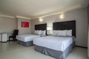 奥里萨巴哈酒店的酒店客房配有两张床和一张书桌