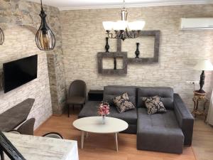 第比利斯ApartHotel Heart of Tbilisi的客厅配有沙发和桌子