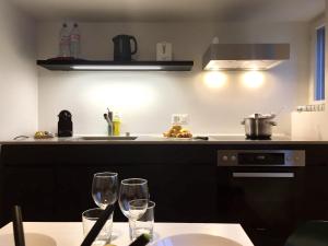 苏黎世VIADUKT公寓式酒店的厨房配有2个餐桌上的酒杯