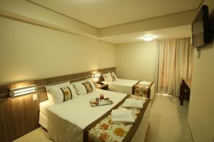 库亚巴派古兹帕拉斯酒店的酒店客房设有两张床和一盘食物