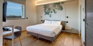菲登扎Park Hotel & Residence by The Cube的一间卧室配有一张床、一张书桌和一个窗户。