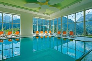 米特尔贝格Hotel Alte Krone的一个带橙色椅子和窗户的游泳池