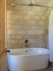 特罗皮克石峡谷旅馆的砖墙浴室内的白色浴缸