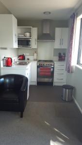 特威泽尔Rosedale Cottages的厨房配有白色橱柜和炉灶烤箱。