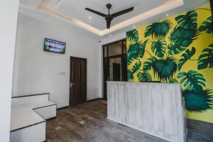 雅加达RedDoorz Plus near Mall Slipi Jaya的一间设有一幅棕榈树画的墙壁的客房