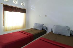 马塔兰Guest House Rumah Lombok Syariah的小型客房 - 带2张床和窗户