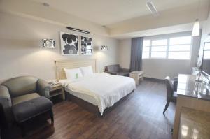 高雄康桥商旅-七贤馆的酒店客房,配有一张床、一张桌子和椅子