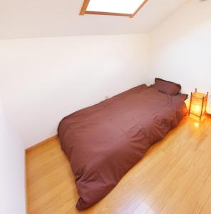 二世古新雪谷纳鲁旅馆的白色房间的床,地板上有一盏灯