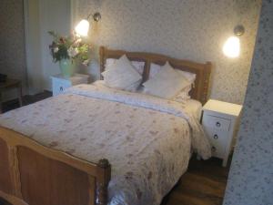 哈穆瓦尔美好时光别墅旅馆的一间卧室配有一张带2个床头柜和2张桌子的床