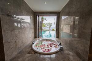 乌鲁瓦图Villa Maiara的带浴缸的浴室和大窗户