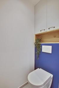凡尔赛L’Alcôve Royale的浴室设有白色卫生间和蓝色的墙壁。
