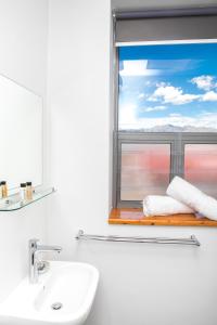 帕尔Zeederberg Corner的一间带水槽的浴室和一个带毛巾的窗户。