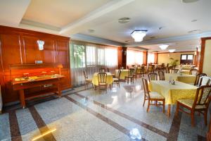 克拉约瓦Hotel Emma Est的一间带桌椅和钢琴的用餐室
