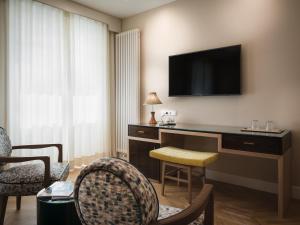 梅拉诺Villa Bavaria的酒店客房设有一张桌子,墙上配有电视