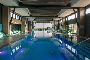 卡布尔Thalazur Cabourg - Hôtel & Spa的一座空的游泳池,里面设有绿色椅子