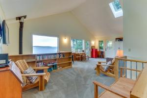 Port LudlowThe Cabin at Oak Bay的客厅配有木制家具和大窗户