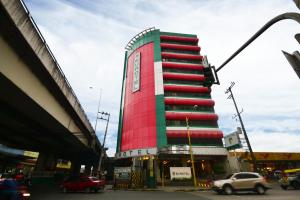 马尼拉亦优泰尔马卡迪酒店的城市街道上的一座红色和绿色的建筑