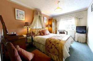 汤顿梅扬别墅酒店的一间卧室配有一张床、一张书桌和一台电视