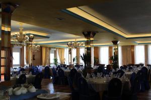 瓜达拉马Hotel Sierra Oriente的宴会厅配有桌椅和吊灯