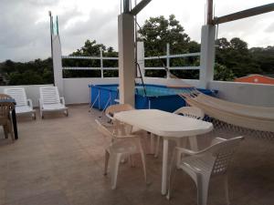 圣安德烈斯I BBBSAI Casa Vacacional en San Andres Islas – Alquiler的门廊配有吊床和桌椅