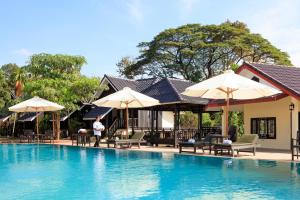 万荣Sansan Resort的度假村的游泳池,配有椅子和遮阳伞