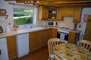 Spilsby1 Hope Cottage的厨房配有木制橱柜、桌子和窗户。