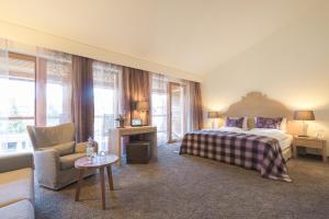 奥伯斯特多夫优雅酒店的一间卧室配有一张床、一张沙发和一把椅子