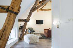皮利尼蒙特拉谢La Maison Deveney Mars的一间带木梁的房间和一间带沙发的客厅