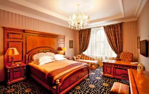 巴库Shah Palace Luxury Museum Hotel的一间卧室配有一张大床和一个吊灯。