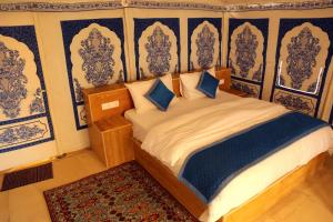 斋沙默尔Exotic Luxury Camps的一间卧室配有蓝色和白色壁纸的床